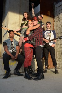 (left to right) Steven Perkins, Becca Brown, Malic White, Luke Linsteadt, David Daniel Smith and Jay Cullen in a publicity image for The Hypocrites’ Chicago premiere of AMERICAN IDIOT with book by Billie Joe Armstrong and Michael Mayer, music by Green Day, lyrics by Billie Joe Armstrong, direction by Steven Wilson and musical direction by Andra Velis Simon. Photo by John Taflan.